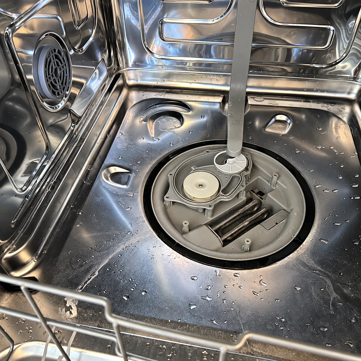 Technician repairing a dishwasher in a customer's home